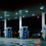 person taking a photo of blue and white gasoline station