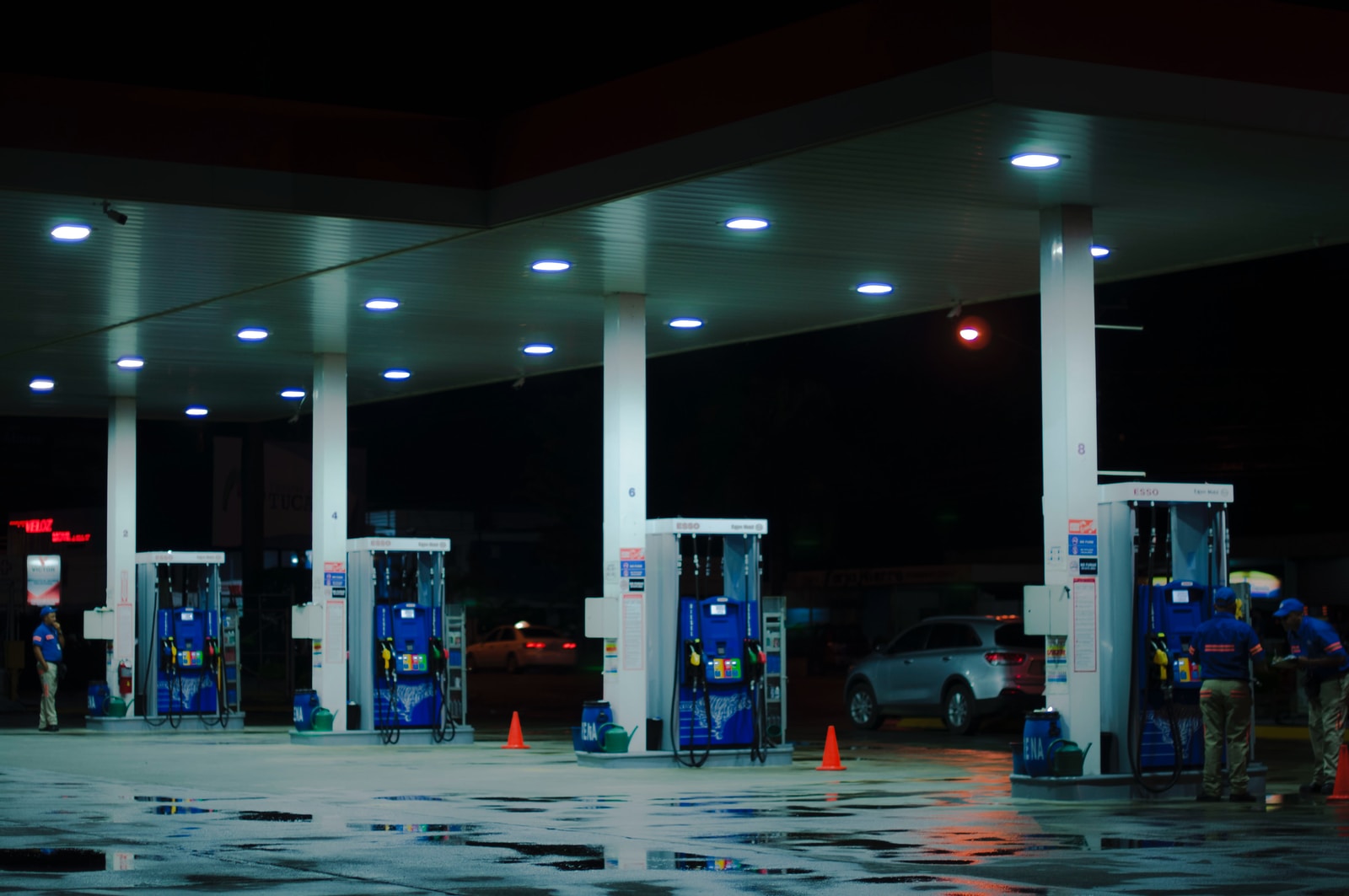 person taking a photo of blue and white gasoline station